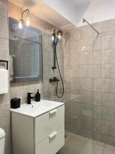 a bathroom with a white sink and a shower at Apartament Corvin 1 in Hunedoara +32 photos