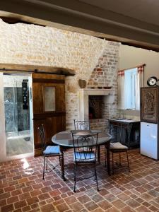 a kitchen with a table and chairs in a room at Le Grenier d'Odette in Sainte-Gemme-la-Plaine