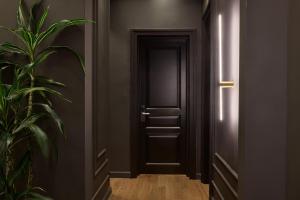 an empty corridor with a black door and a plant at Athens Icon Collection in Athens