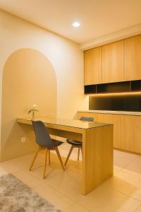 a kitchen with a wooden table and two chairs at Cozy City, Large studio stay for couple or family , Riverine Diamond in Kuching +1 photo