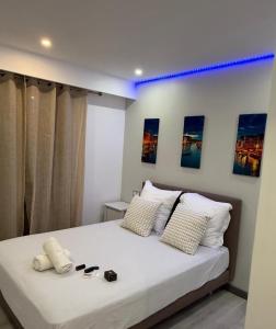 a bedroom with a large white bed with shoes on it at Appartement Valeria in Saint-Laurent-du-Var