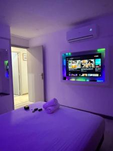 a bedroom with a bed with a tv on the wall at Appartement Valeria in Saint-Laurent-du-Var