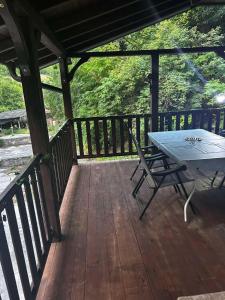a table and a chair on a wooden deck at Vila Lush in Sarajevo