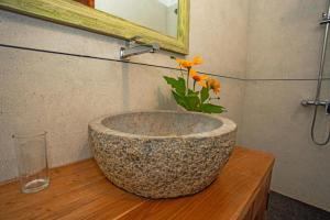 a bathroom with a stone bowl with a flower in it at Villa Nirvana in Unawatuna +31 photos