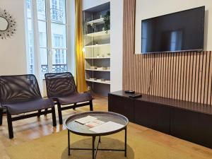 ein Wohnzimmer mit zwei Stühlen und einem Fernseher in der Unterkunft Calm apt 60m2 near Notre-Dame and Seine 2bdrs N4-4b in Paris