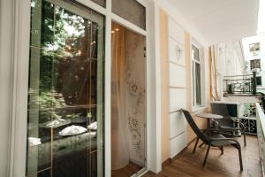 Habitación con puerta de cristal, silla y mesa. en Moncastro Бутік-готель, en Odessa
