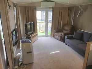 a living room with a television and a couch at Parkview Billing Aquadrome in Great Billing