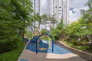 une aire de jeux avec toboggan dans un parc avec de grands bâtiments dans l'établissement Glan House & Glan Store, à Séoul