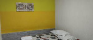 a room with a bed and two pictures on the wall at Yellow Hostel in São Paulo
