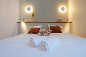 a white bed with two pillows on top of it at Hotellerie de l'Abbaye du Désert in Bellegarde