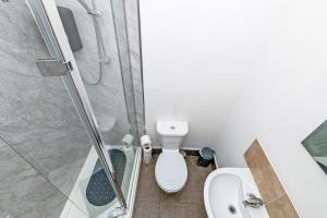 a bathroom with a shower and a toilet and a sink at Colwyn Bay Two Bedroom Apartment by Guestz in Colwyn Bay +4 photos