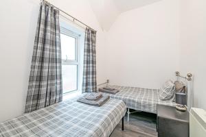 a bedroom with two beds and a window at Colwyn Bay Two Bedroom Apartment by Guestz in Colwyn Bay