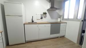 a kitchen with white cabinets and a refrigerator at Apartamento Murales de Talavera in Talavera de la Reina +15 photos