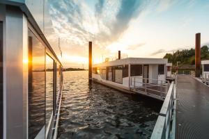 a boat is docked at a dock in the water at Hausboote am Lankenauer Höft in Bremen