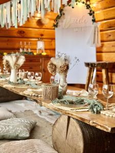 a wooden table with wine glasses and a table sign at BUKOWA Jezioro Żywieckie Beskid Żywiecki Śląski Sauna Jacuzzi Kominek Morsowanie Tresna Żywiec Szczyrk in Tresna