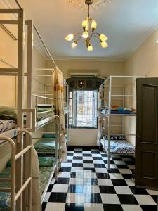 a room with bunk beds and a checkered floor at Hnhome28 in Hanoi