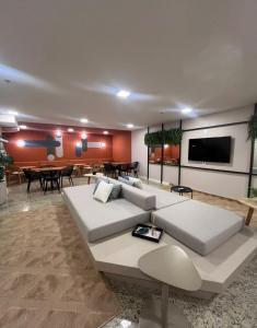 a living room with a white couch and a tv at Studio Alto Padrão Centro do Rio in Rio de Janeiro