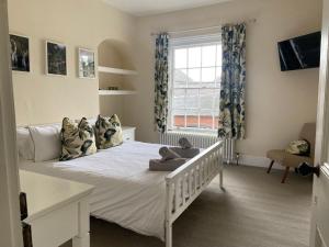 ein Schlafzimmer mit einem Bett, auf dem ein Teddybär liegt in der Unterkunft Town centre Victorian period 3 bedroom home in Bishops Castle