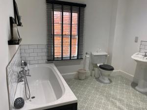 ein Badezimmer mit Badewanne, Toilette und Waschbecken in der Unterkunft Town centre Victorian period 3 bedroom home in Bishops Castle + 9 Fotos