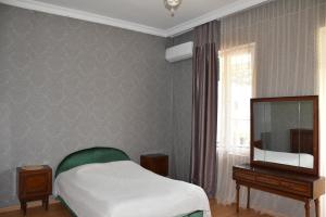 a bedroom with a bed and a flat screen tv at Nona's House in K'obulet'i