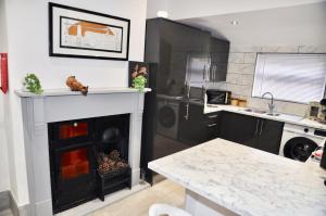 a kitchen with a fireplace in the middle of a room at The Great Escape by Tŷ SA in Newport