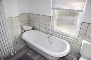 a white bath tub in a bathroom with a window at The Great Escape by Tŷ SA in Newport