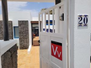 Una puerta blanca con un cartel al lado de un edificio en Lust4Life Mirage - Luxury villa with pool, en Playa Blanca
