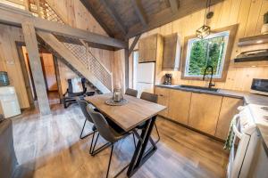 a kitchen and dining room with a table in a cabin at Spa and Nature - Chalet des Pins Rouge in Saint-Paul-de-Montminy