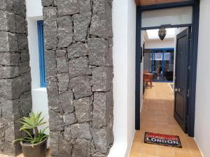 una pared de piedra separa el pasillo de la casa en Lust4Life Mirage - Luxury villa with pool, en Playa Blanca
