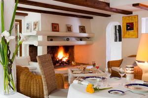 a living room with a table and a fireplace at Mangio Fango Hotel et Spa in Saintes-Maries-de-la-Mer