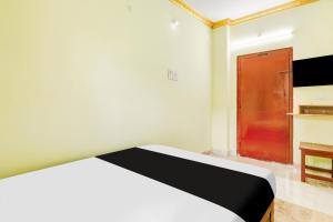a bedroom with a bed and a red door at Hotel O V Guest In in Guntūr