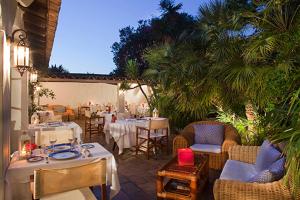 a patio with tables and chairs and a restaurant at Mangio Fango Hotel et Spa in Saintes-Maries-de-la-Mer