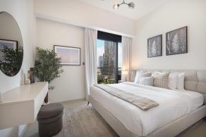 um quarto branco com uma cama grande e uma janela em Act 1 Act 2 Towers, Luxury 4BR, Full Burj Khalifa View Balcony, Pool, Gym no Dubai