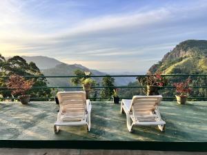 two chairs on a balcony with a view of mountains at Ambiente Guest House in Ella