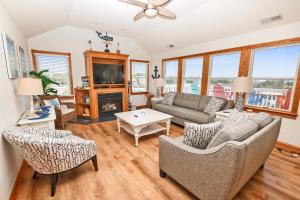 a living room with a couch and chairs and a tv at Soundside, Private Pool, Hot Tub, Rec Room-VOH50, Castle in the Sand in Corolla