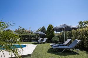 a group of chairs and umbrellas next to a pool at Villa Lambros in Roústika +44 photos