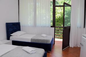 a bedroom with two beds and a door to a window at Kiki Hotel in Velipojë +15 photos