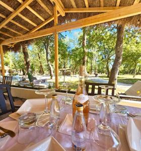 a table with glasses and a bottle of wine on it at Glamping Neptun in Ulcinj