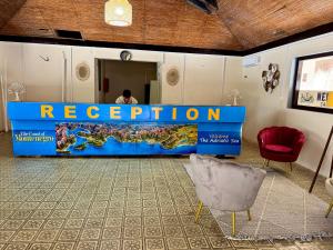 a reception desk in a room with a person in the background at Glamping Neptun in Ulcinj