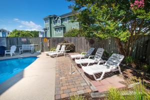 a group of lawn chairs sitting next to a pool at Soundside, Private Pool, Hot Tub, Rec Room-VOH50, Castle in the Sand in Corolla