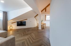 a living room with wooden flooring and a tv at Griunvaldo apartamentai in Kaunas