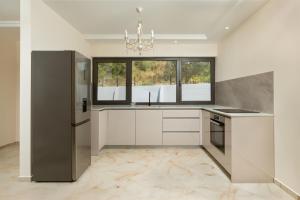 a kitchen with white cabinets and a chandelier at Villa Boka in Tivat
