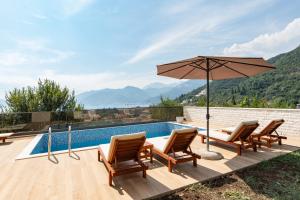 a patio with chairs and an umbrella next to a swimming pool at Villa Boka in Tivat