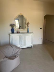 a living room with a mirror and a white dresser at Casa Manu in Gallipoli