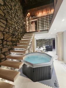 a hot tub in a room with a stone wall at White Loft & spa in Viterbo