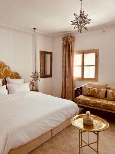 a bedroom with a large bed and a couch at Riad Dar Elif in Tangier