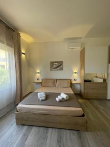 a bedroom with a large bed with towels on it at B&B Magiulsà in Siniscola