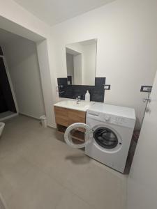 a bathroom with a washing machine and a sink at Appartamento a due passi dal mare in Martinsicuro +2 photos