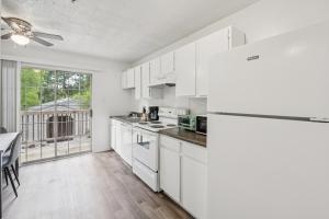 a kitchen with white appliances and a table and a window at Kenridge Apartments 1230 I Comfy 2 Bed 2 Bath in Decatur