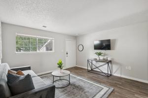 a living room with a couch and a tv at Kenridge Apartments 1635 I Comfy 2 Bed 2 Bath in Decatur